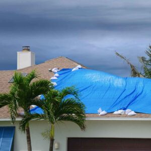 Blue tarp installed on residential roof after storm damage for temporary protection