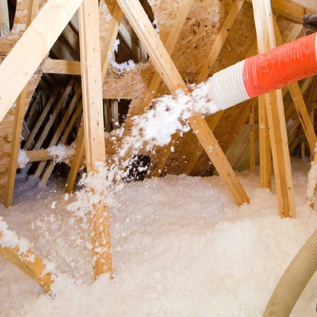 Loose-fill attic insulation being sprayed into place.