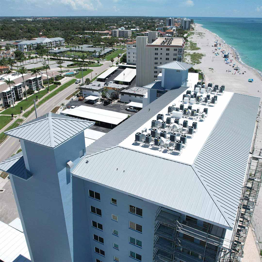Aerial view of a large commercial building with a white flat roof.